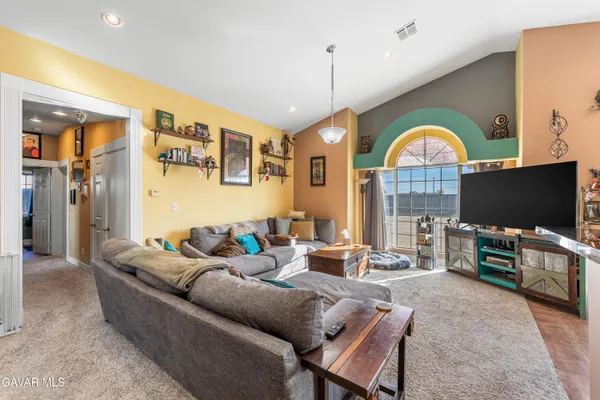 a living room with furniture a flat screen tv and a large window