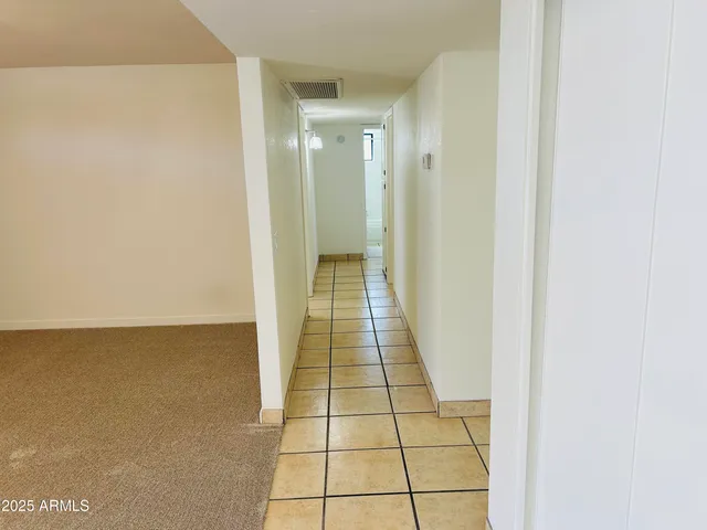 an empty room with a window and a fan