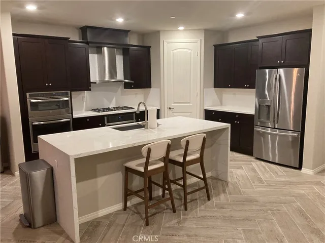 a kitchen with a refrigerator a microwave a dining table and chairs