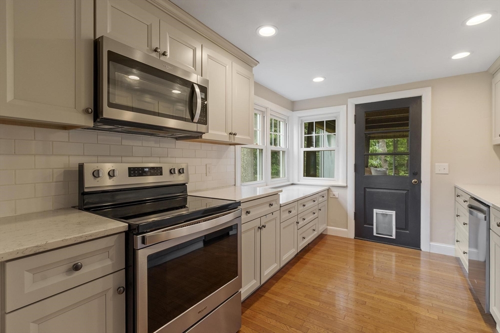 167 Gates Pond Road Berlin, MA 01503 - Photo 13 of 32 a kitchen with stainless steel appliances a stove microwave and cabinets
