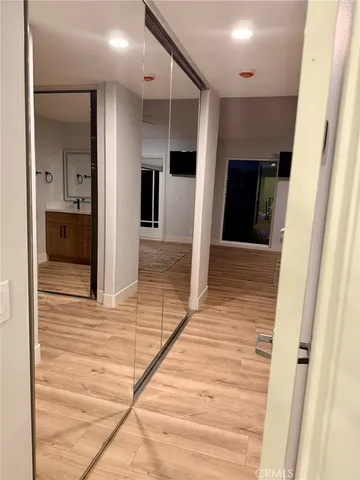 a hallway with wooden floor and staircase