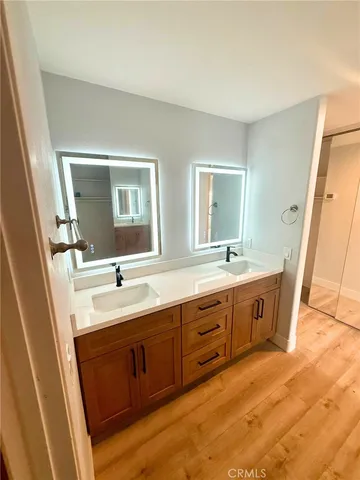 a spacious bathroom with double vanity sink a mirror and a bathtub