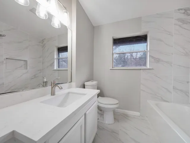a bathroom with a sink a toilet and bathtub