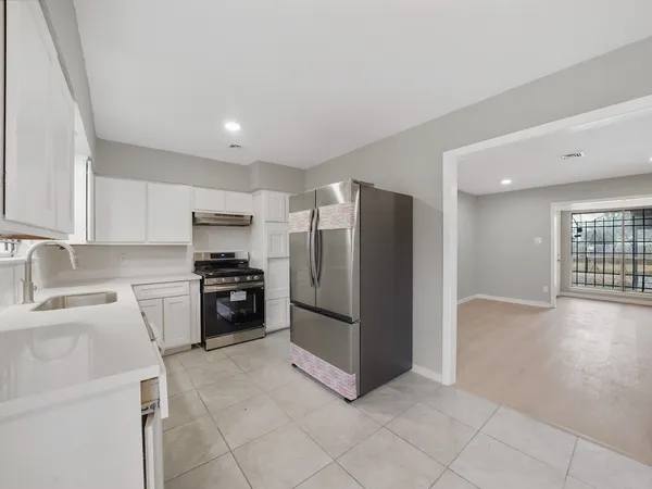 a kitchen with a refrigerator sink and cabinets