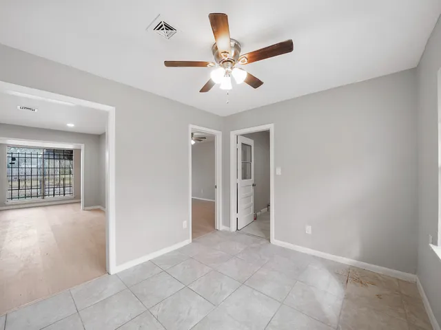 an empty room with closet and windows