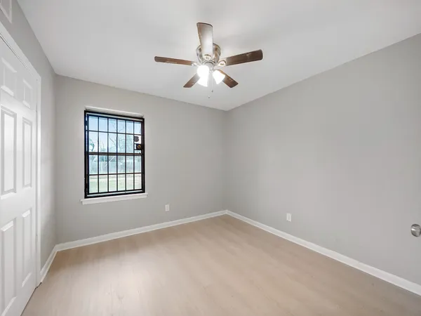 an empty room with a window and a fan