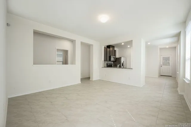 an empty room with a bathroom and mirror