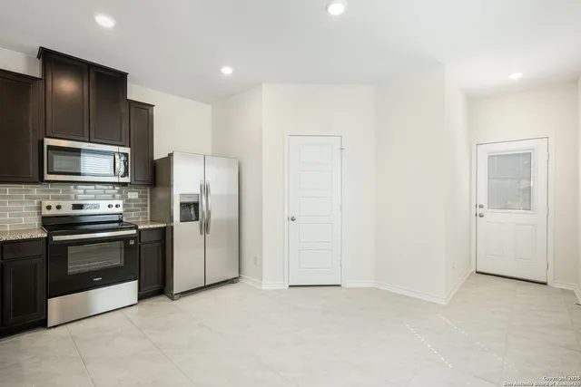 a large kitchen with cabinets and stainless steel appliances