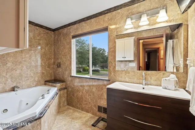 a bathroom with a bathtub sink and mirror