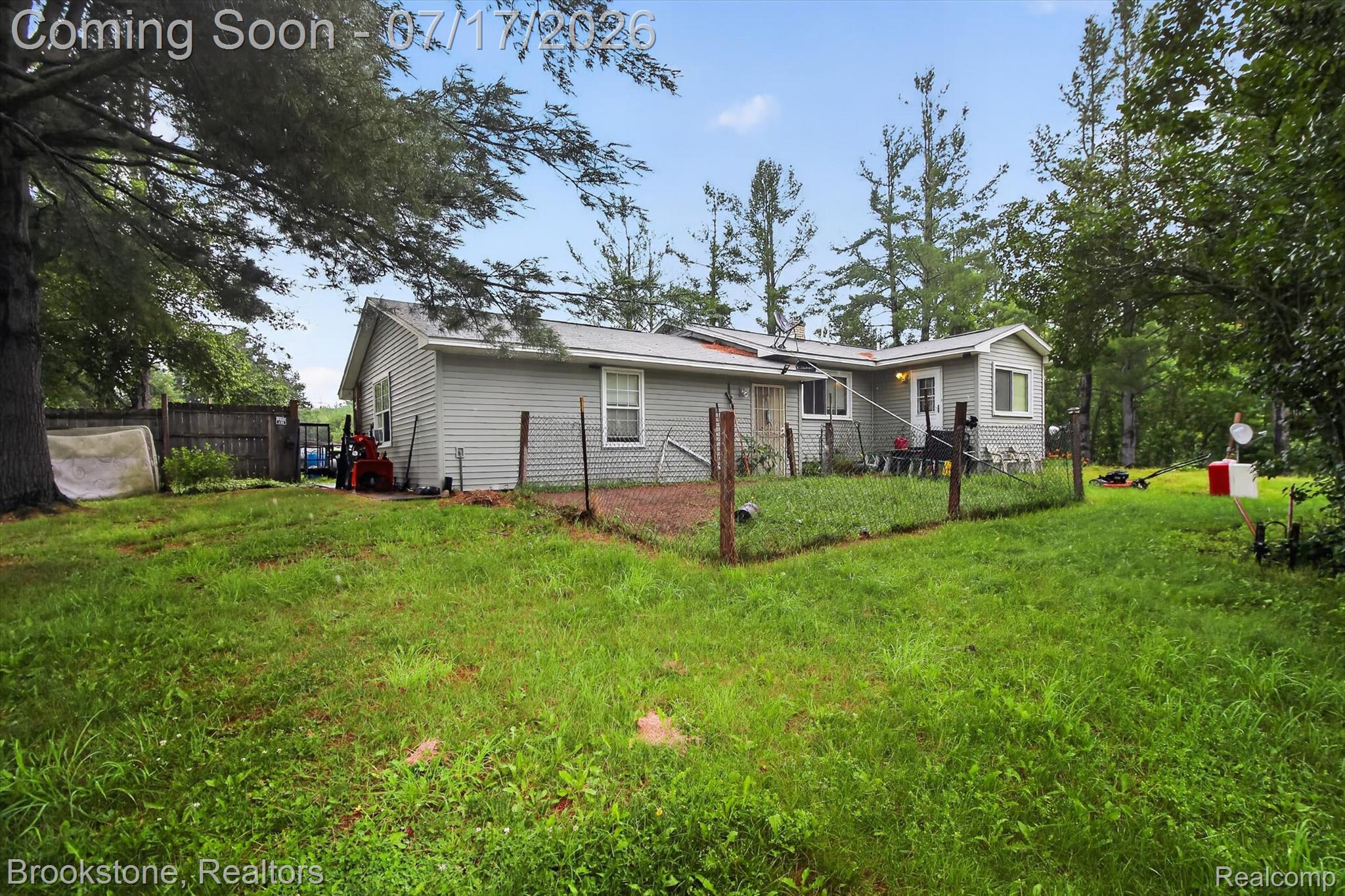 22709 Pleasant Valley Road Hillman, MI 49746 - Photo 32 of 42 Spacious backyard featuring a chain-link fence enclosure, mature perimeter trees, and a wooden privacy fence
