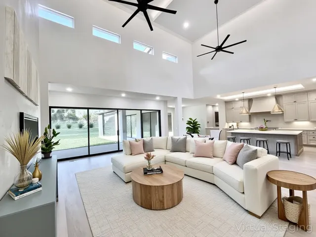 a large kitchen with kitchen island a sink dishwasher stove and white cabinets with wooden floor