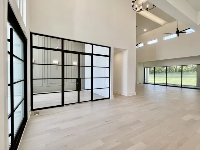 a living room with furniture and a large window with garden view