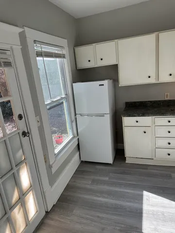 a kitchen with white cabinets and white appliances
