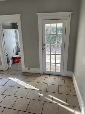 a room with a black white checkered floor next to a window