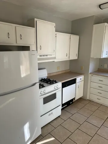 a kitchen with granite countertop white cabinets and white appliances