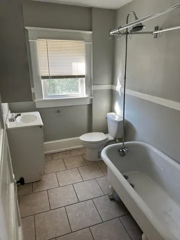 a bathroom with a tub a sink and a window