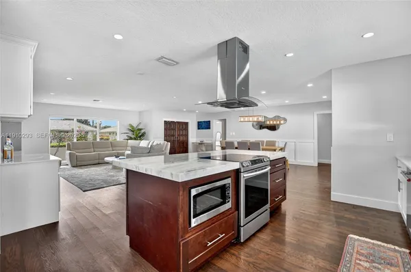 a kitchen with stainless steel appliances granite countertop a stove and a wooden floors