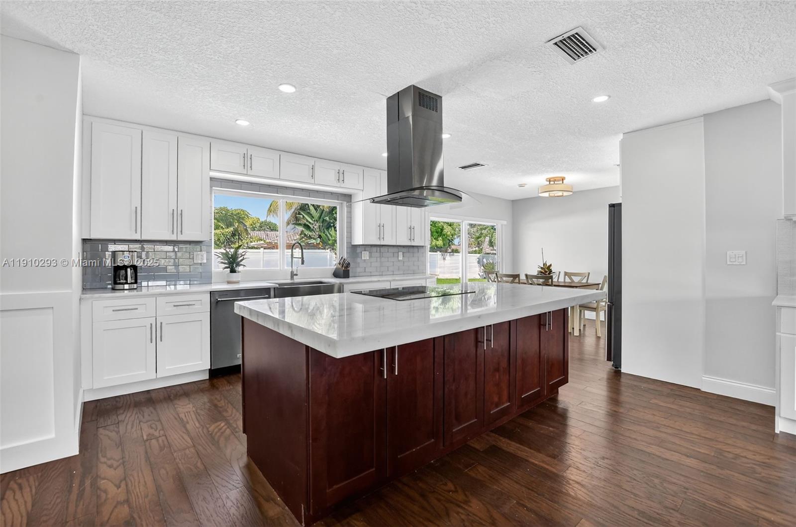 5660 Golfway Drive Boca Raton, FL 33433 - Photo 13 of 41 a kitchen with kitchen island granite countertop a sink cabinets and wooden floor