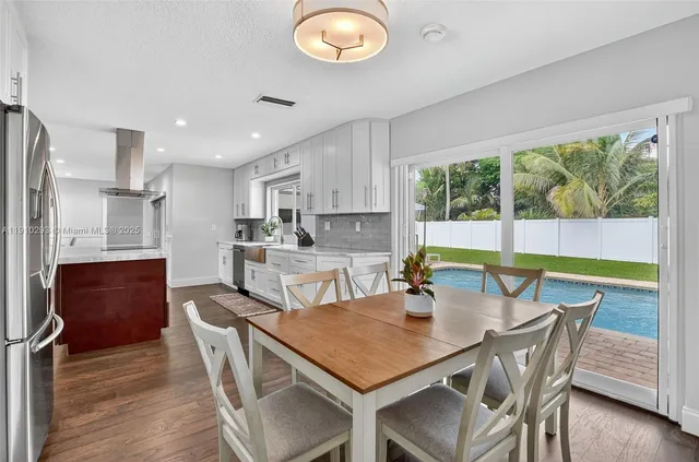 a view of a dining room with furniture a chandelier and wooden floor