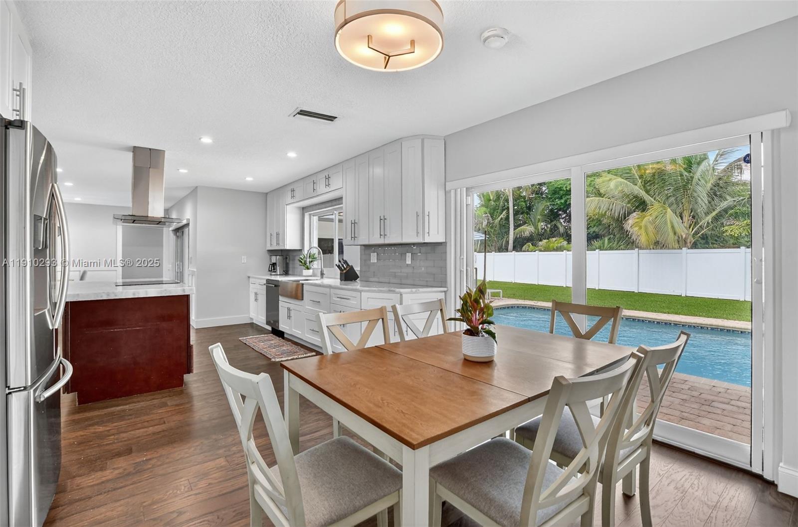 5660 Golfway Drive Boca Raton, FL 33433 - Photo 17 of 41 a view of a dining room with furniture a chandelier and wooden floor