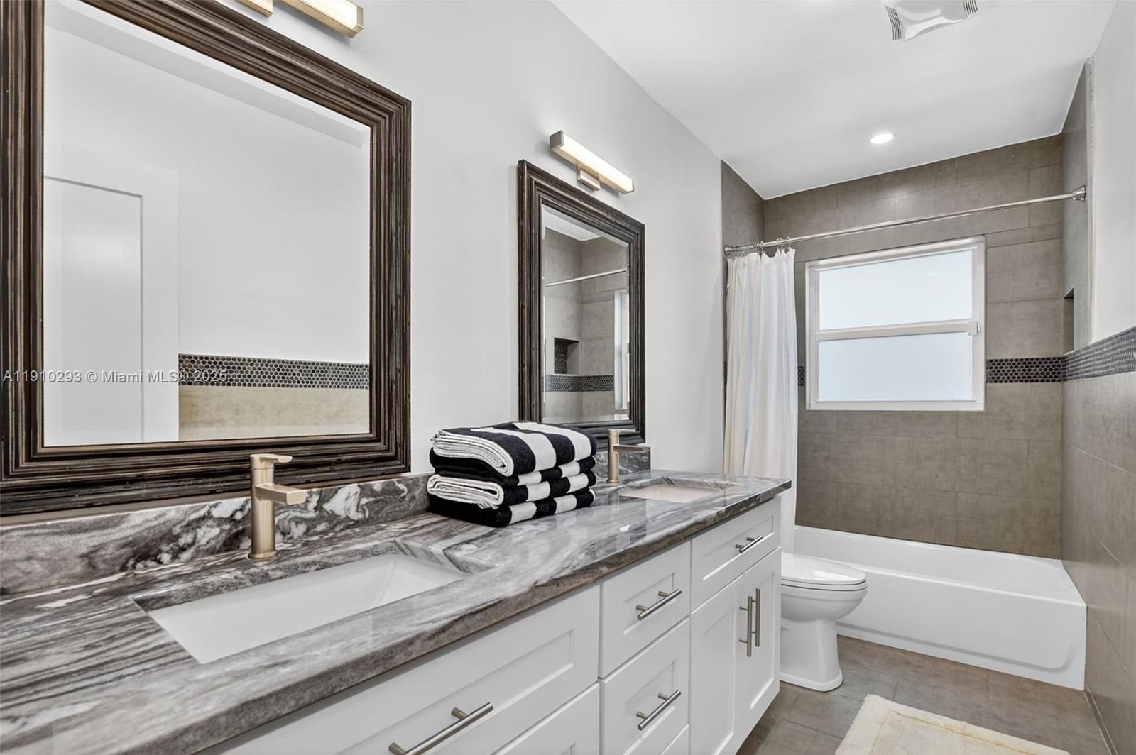 5660 Golfway Drive Boca Raton, FL 33433 - Photo 21 of 41 a bathroom with double vanity sinks a toilet and a large mirror