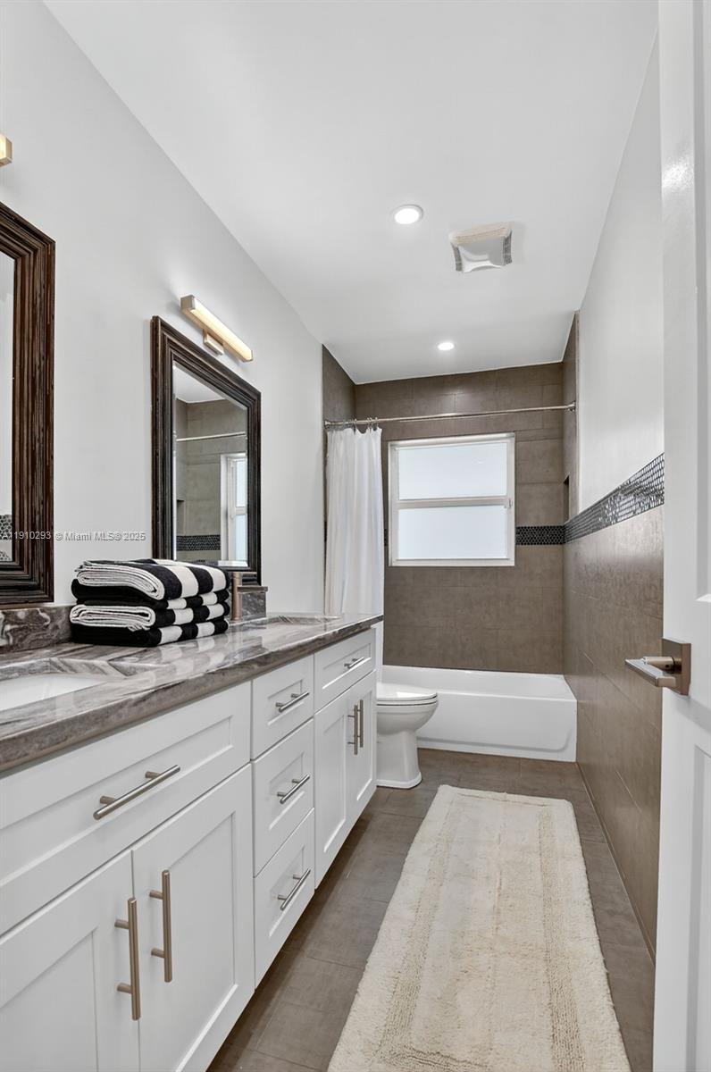 5660 Golfway Drive Boca Raton, FL 33433 - Photo 22 of 41 a spacious bathroom with a double vanity sink a large mirror and a bathtub