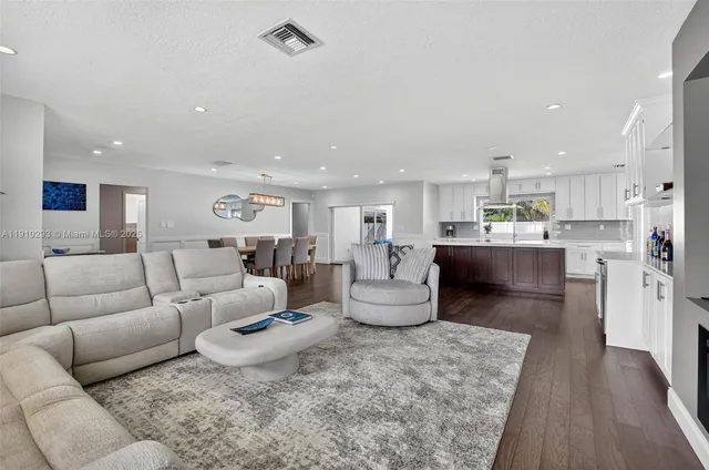 a living room with furniture and a kitchen view