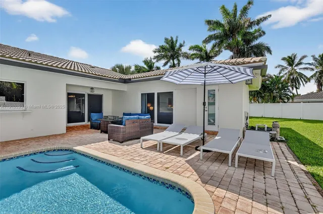 a view of a house with backyard and sitting area