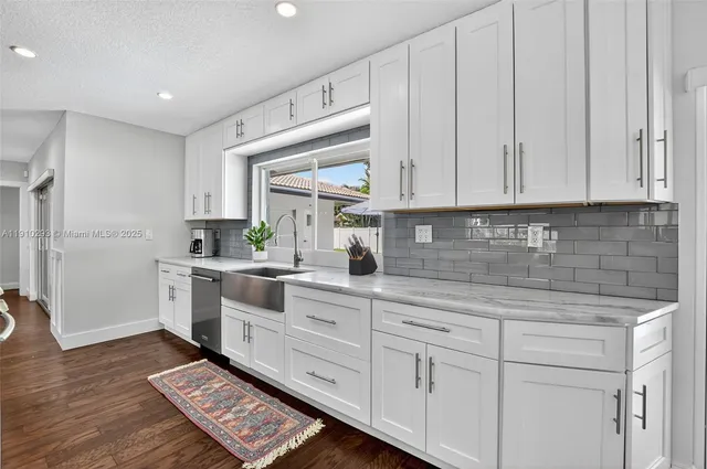 a kitchen with white cabinets and white appliances