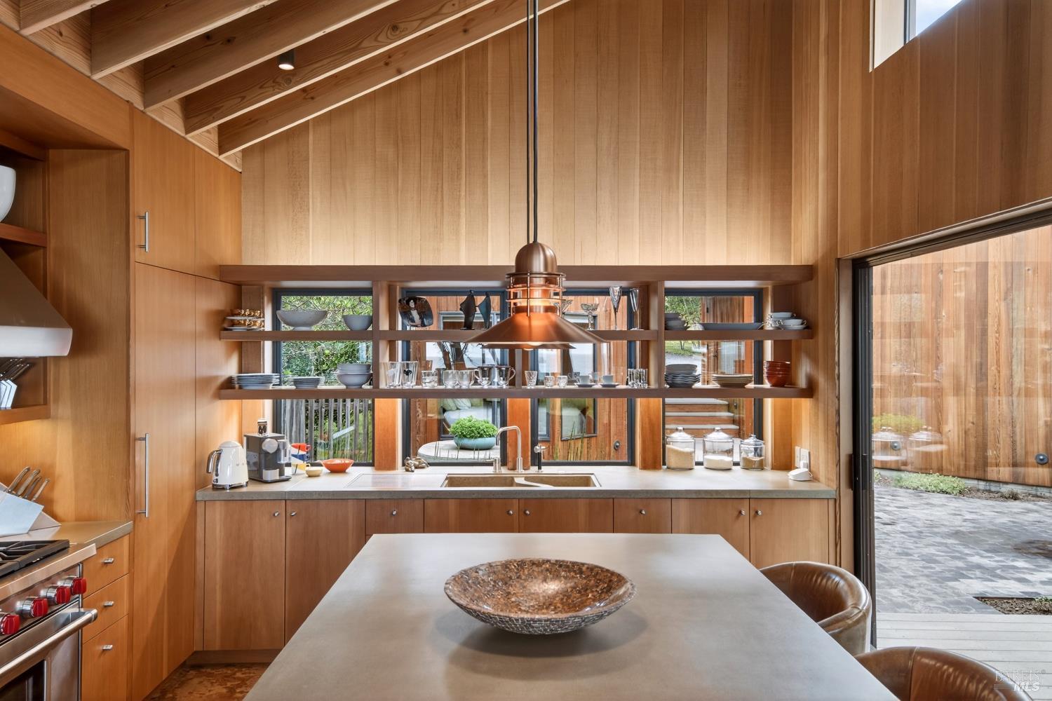 233 Solstice The Sea Ranch, CA 95497 - Photo 22 of 90 Kitchen island with pendant lighting and open shelving looking into courtyard