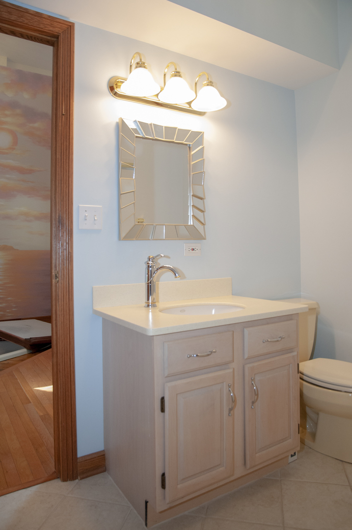 201 East Army Trail Road Bartlett, IL 60103 - Photo 36 of 59 a bathroom with a sink a toilet and mirror
