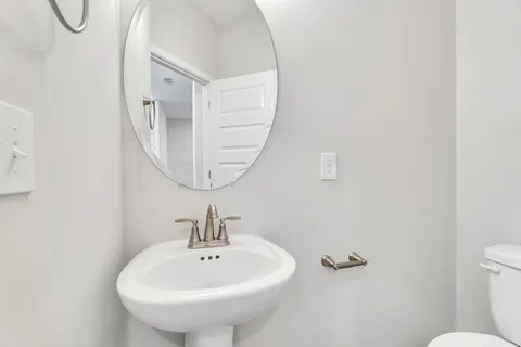 a bathroom with a sink a mirror and a toilet