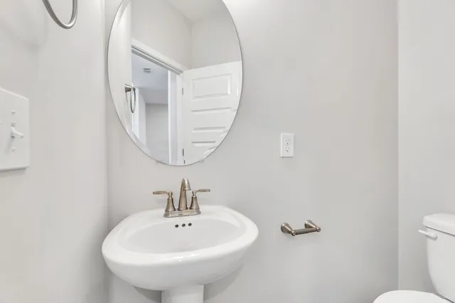a bathroom with a sink a mirror and a toilet