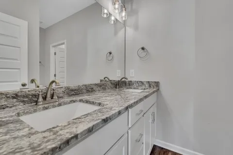 a bathroom with a granite countertop sink and a mirror