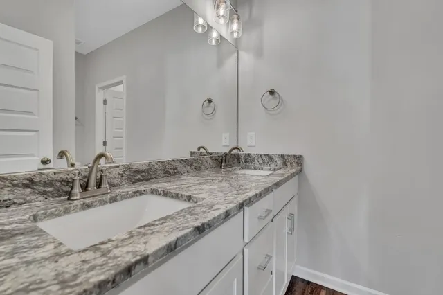 a bathroom with a granite countertop sink and a mirror