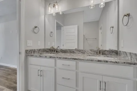 a bathroom with a granite countertop sink and a mirror