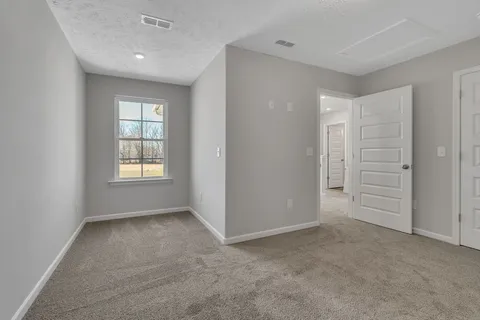 an empty room with windows and closet