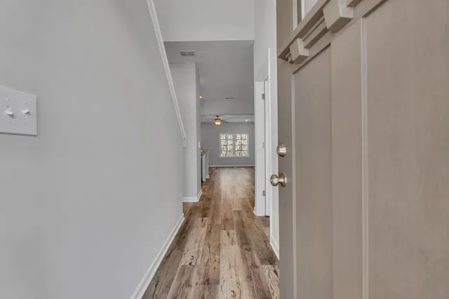 a view of a hallway with wooden floor and staircase