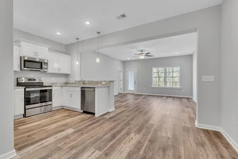 a kitchen with granite countertop a stove top oven and cabinets