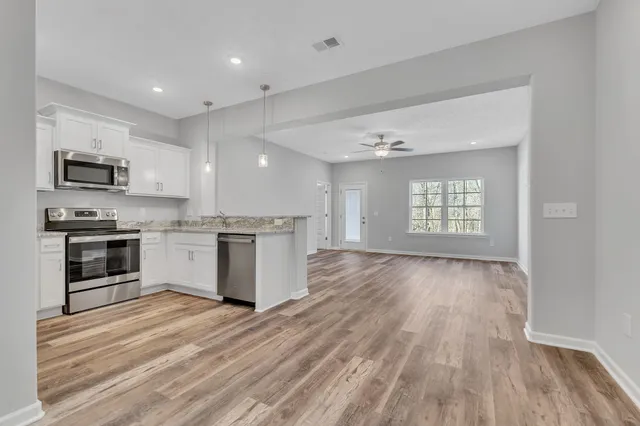 a kitchen with granite countertop a stove top oven and cabinets