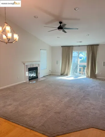 a view of an empty room with a fireplace and a window