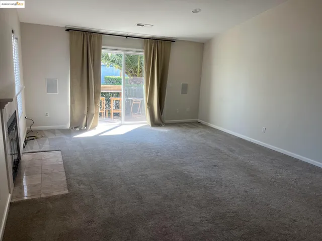 an empty room with windows and fireplace