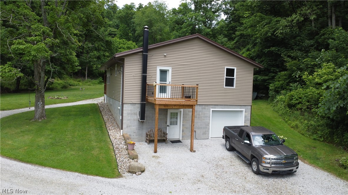View of front of home with a garage, a balcony, and a front lawn