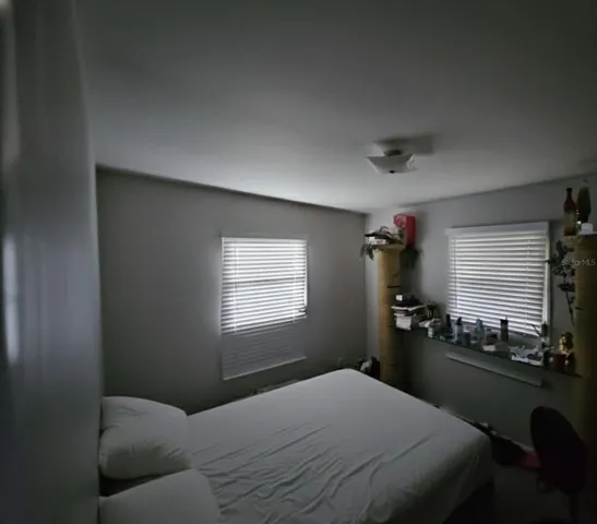 a bedroom with a bed and window with desk