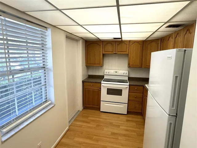a kitchen with a white stove refrigerator and cabinets