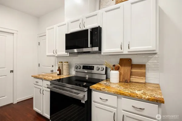 a kitchen with stainless steel appliances granite countertop a stove a microwave and sink