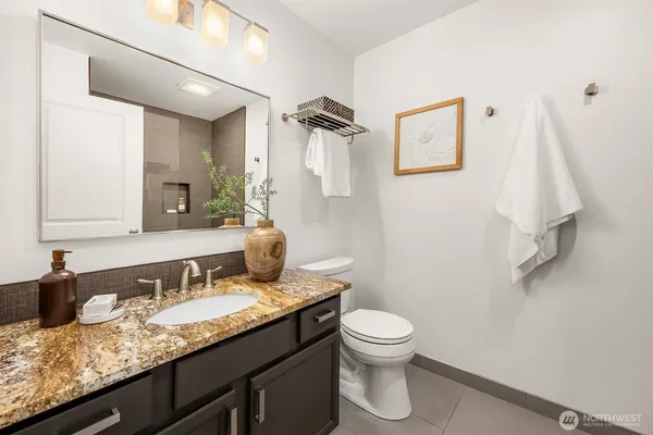 a bathroom with a granite countertop sink toilet and shower