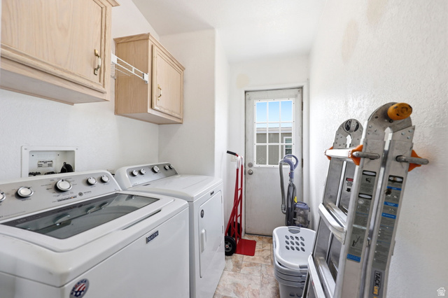 2491 Highway 89, Unit 614 Pleasant View, UT 84404 - Photo 21 of 27 Utility room featuring upper cabinetry, a white exterior door with window panes, and patterned flooring
