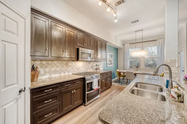 a kitchen with granite countertop a sink stove and cabinets