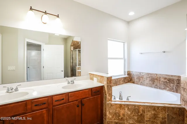 a bathroom with a tub sink and mirror